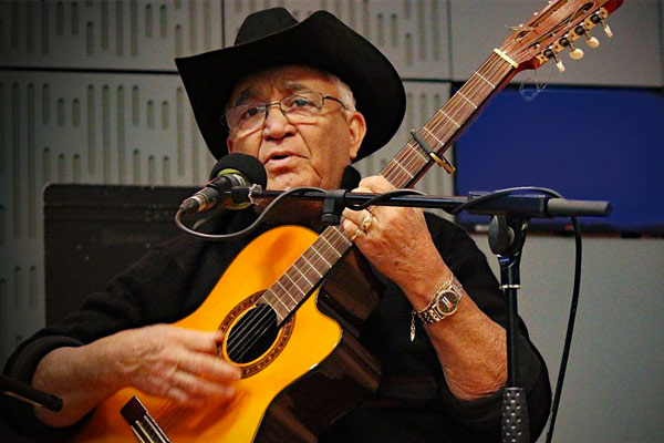 Eliades Ochoa performs with guitar on stage