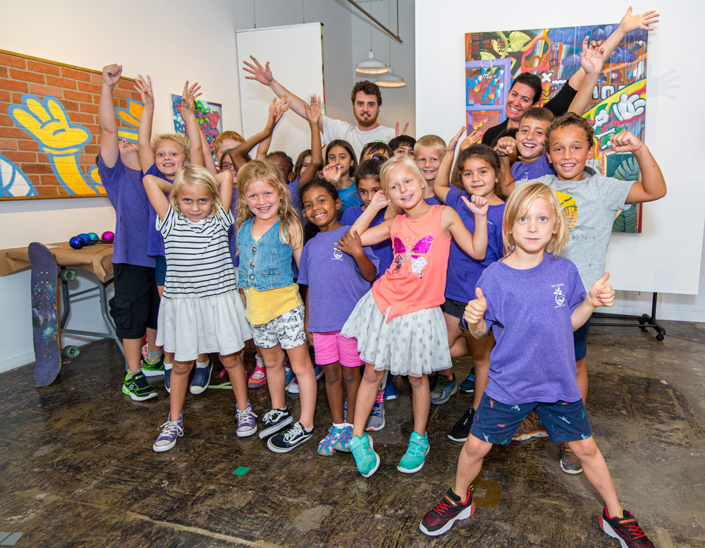 Kids in the gallery with the Artist in front of Artwork