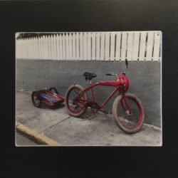 photo of a red bicycle in front of a white picket fence