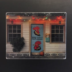 Festive house with blue door depicting rooster heads