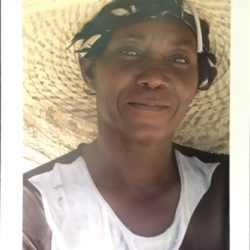 Photograph portrait of a Haitian woman wearing a straw hat