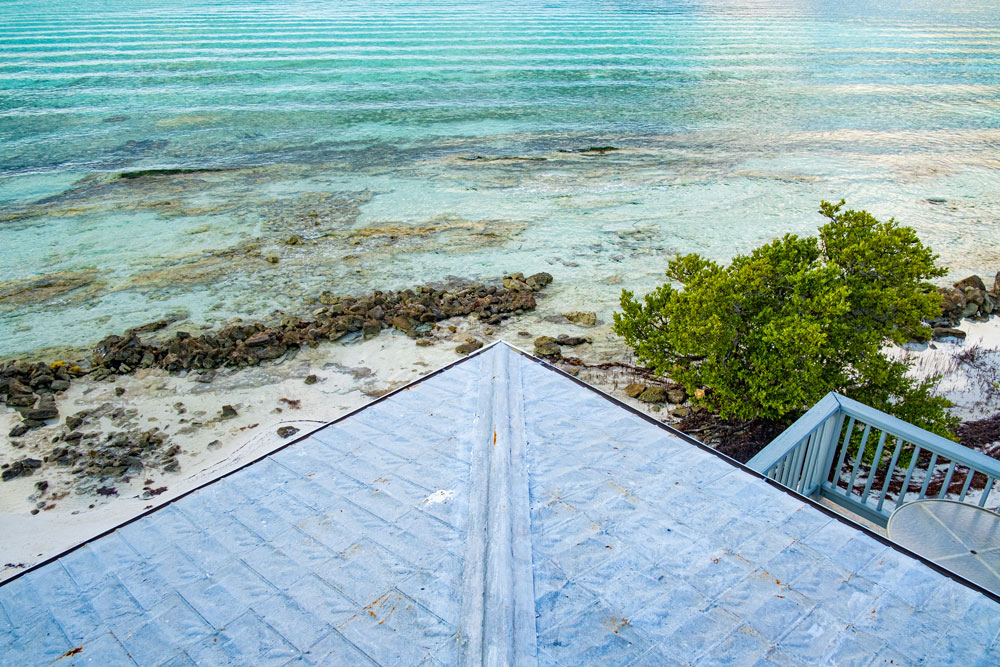 Photo of a corner of a roof line from above looking down at the water and beach
