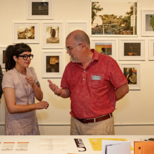 photo of The Studios Executive Director in conversation at art exhibit opening