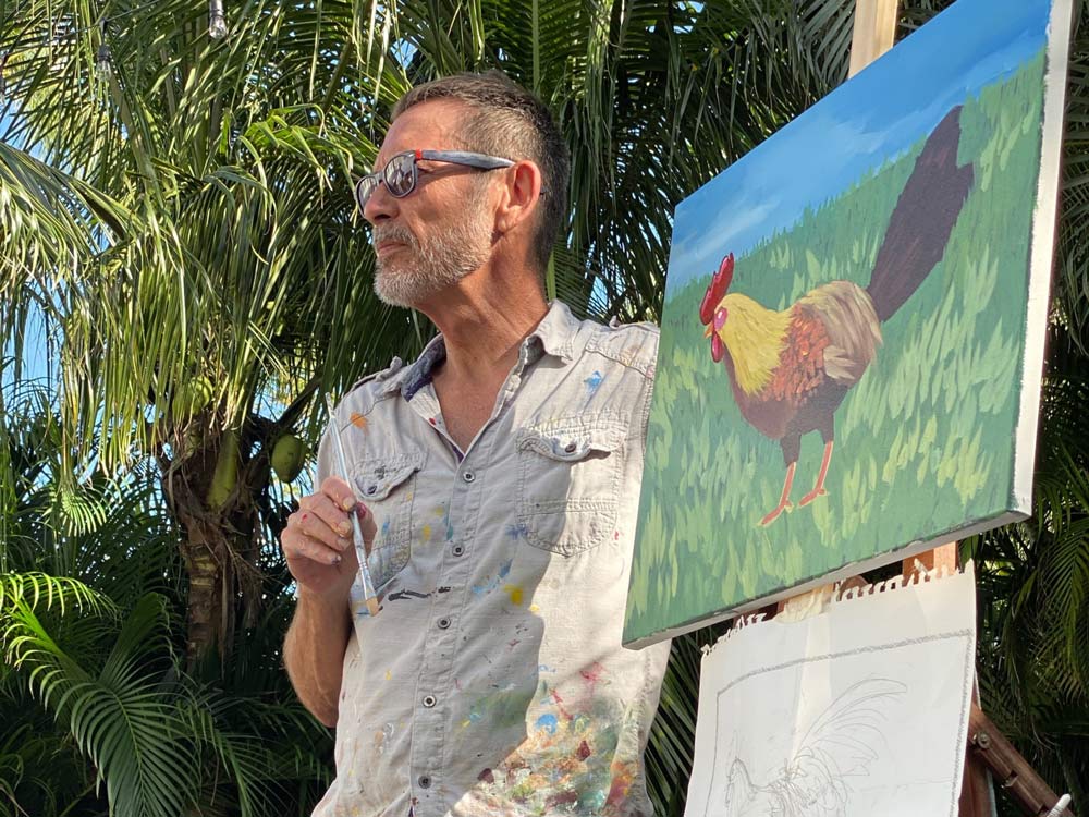 Photo of painter and The Studios instructor Rick Worth standing with painted portrait of rooster