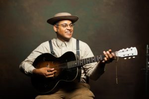 A founding member of the Carolina Chocolate Drops, GRAMMY Award Winner and two-Time EMMY Nominee Dom Flemons has earned the moniker “The American Songster.” With a repertoire covering over 100 years of early American popular music, Flemons masterfully plays everything from banjo and harmonica to fife and rhythm bones.