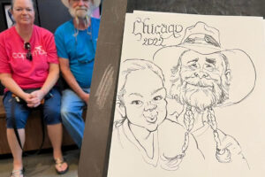 Photo of an easel with a caricature drawing of a couple - woman on left and a man with a white beard braided into two sections.