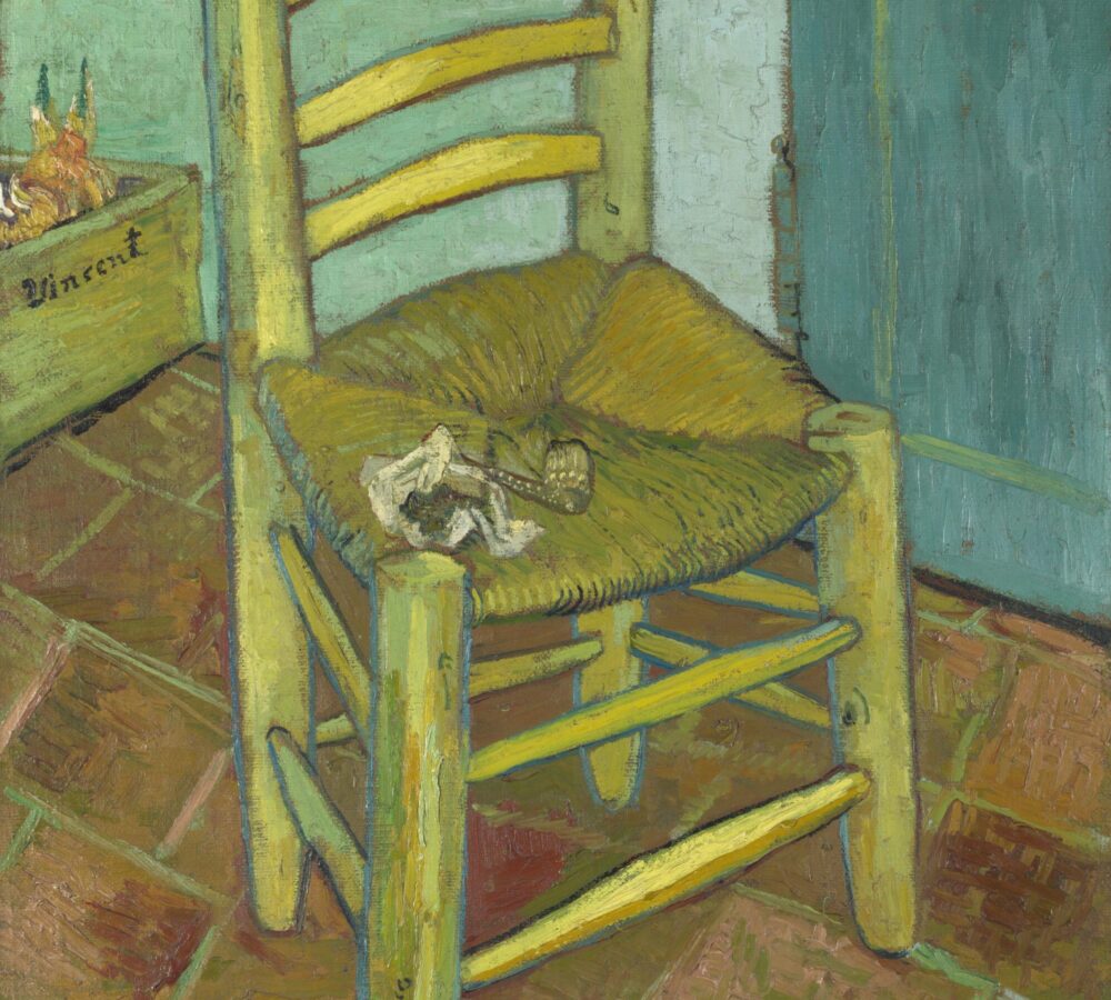 Famous Vincent van Gogh painting of a rustic yellow wooden chair with a woven seat, pipe and pouch resting on top, placed against a green-blue wall and tiled floor.